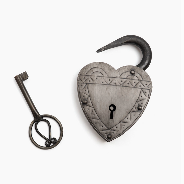 Heart-shaped padlock with a key on a white background