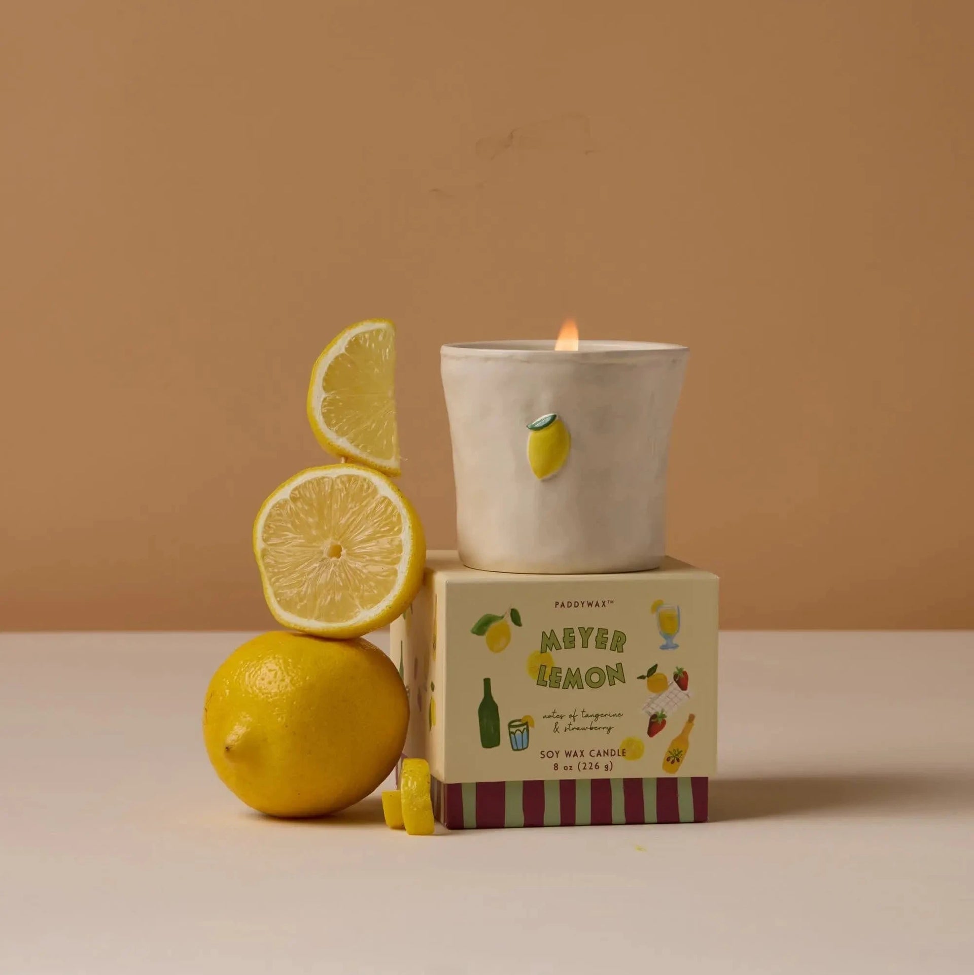 Meyer Lemon candle with lemons on a beige background