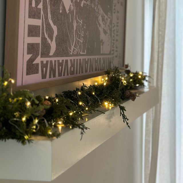 Decorative Christmas pine greenery garland with lights and pine cones 