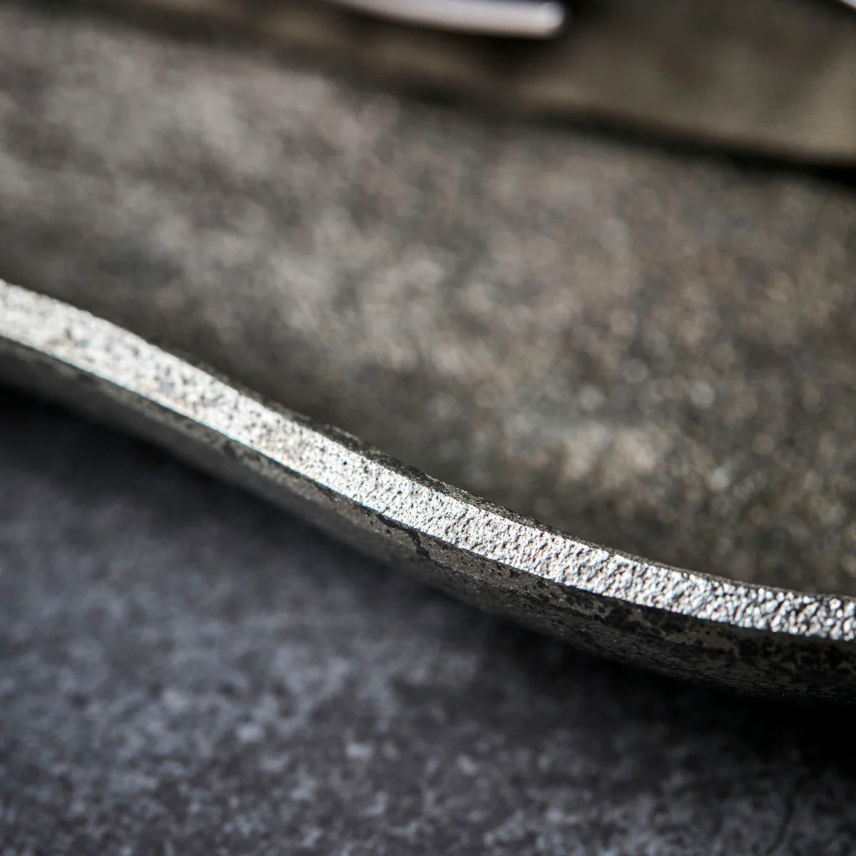 Close-up of a textured metal serving tray with a blurred background
