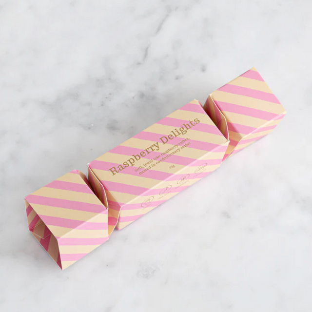 Pink and yellow striped candy bar with 'Raspberry Delights' text on a marble surface