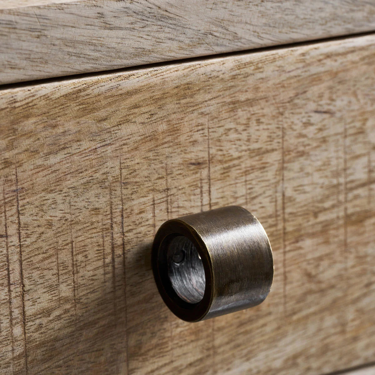 Brass cabinet knob on a wooden drawer